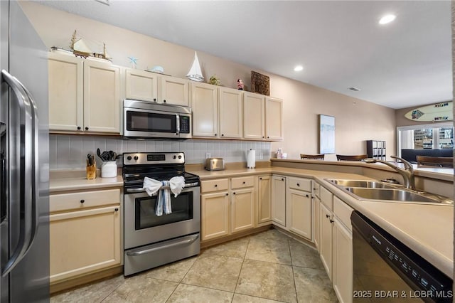 kitchen featuring a sink, backsplash, appliances with stainless steel finishes, and light countertops