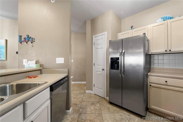 kitchen featuring light tile patterned floors, a textured ceiling, stainless steel appliances, and light countertops