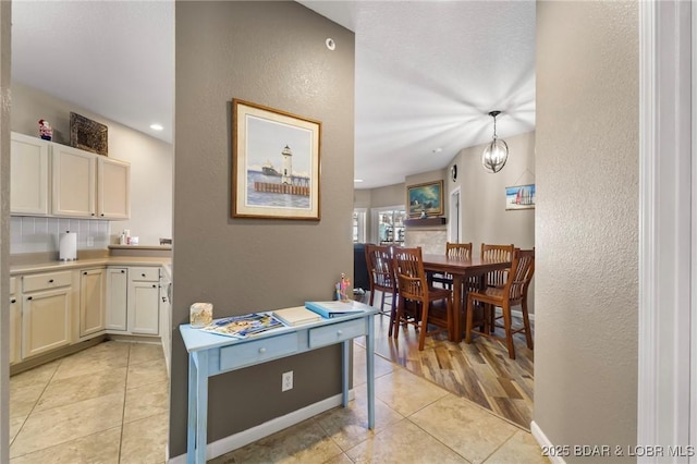 kitchen with baseboards, tasteful backsplash, light tile patterned flooring, and light countertops