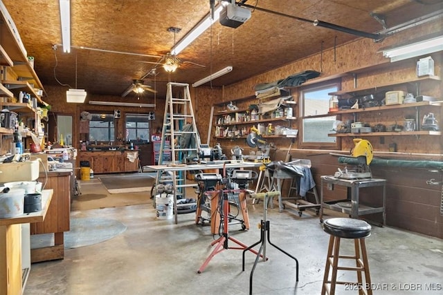 misc room featuring a workshop area, a garage, and concrete flooring