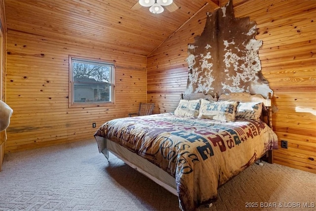 bedroom with vaulted ceiling, wood walls, and carpet floors