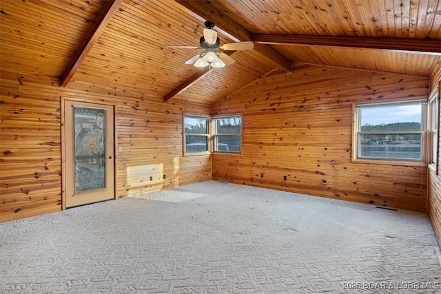 additional living space featuring carpet flooring, vaulted ceiling with beams, a ceiling fan, and wood walls