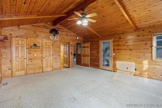 interior space with lofted ceiling with beams, a ceiling fan, wood walls, and wooden ceiling