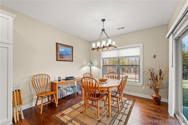 dining area featuring a notable chandelier, visible vents, baseboards, and wood-type flooring