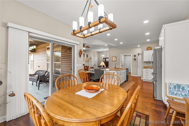 dining room featuring ceiling fan with notable chandelier, recessed lighting, and dark wood-style flooring