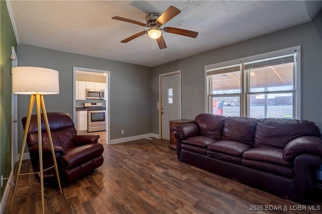 living area featuring a ceiling fan, baseboards, and dark wood-style flooring