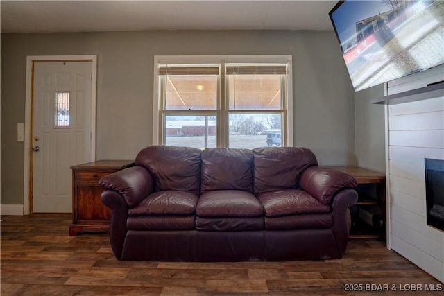 living room with dark wood finished floors and a glass covered fireplace