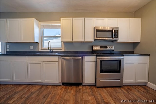 409 S Walnut St, Versailles, MO 65084 - kitchen featuring appliances with stainless steel finishes, dark countertops, white cabinets, and dark wood-style floors