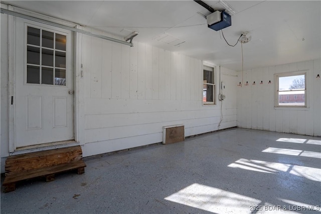 409 S Walnut St, Versailles, MO 65084 - garage featuring a garage door opener and wood walls