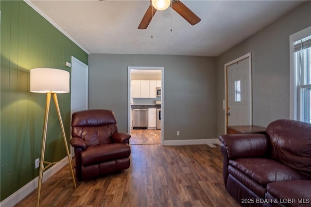 living room with baseboards, wood finished floors, and a ceiling fan