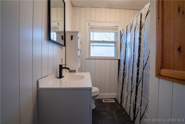 bathroom with visible vents, wood walls, toilet, a shower with curtain, and vanity