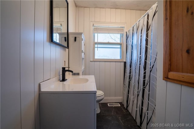 409 S Walnut St, Versailles, MO 65084 - bathroom featuring toilet, vanity, a shower with shower curtain, marble finish floors, and a decorative wall