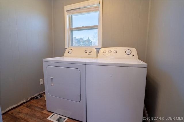 laundry room featuring dark wood finished floors, laundry area, visible vents, and separate washer and dryer