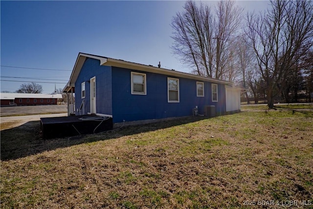 409 S Walnut St, Versailles, MO 65084 - view of property exterior with a yard, central AC unit, and concrete block siding