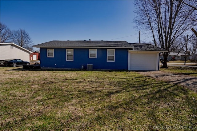 back of property with an attached garage, a yard, driveway, and central AC