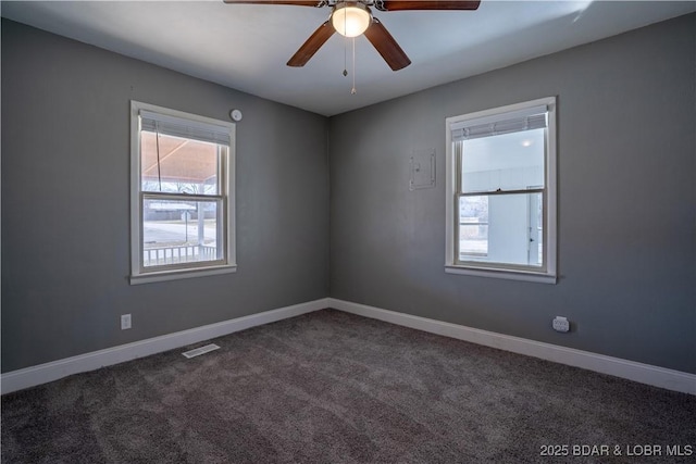 carpeted spare room with a ceiling fan, visible vents, and baseboards