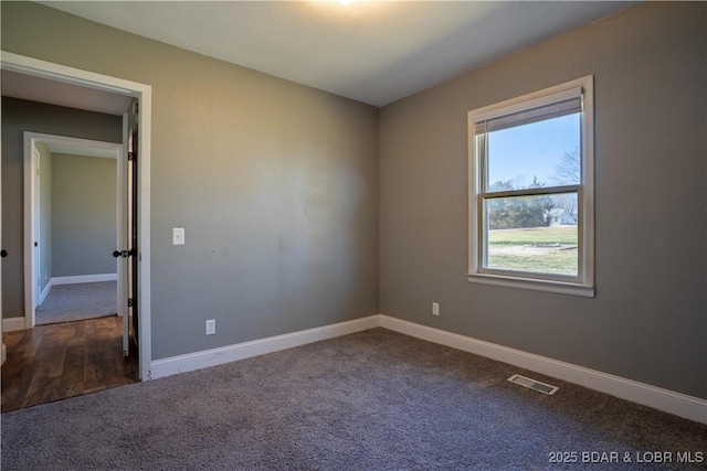 carpeted spare room featuring visible vents and baseboards