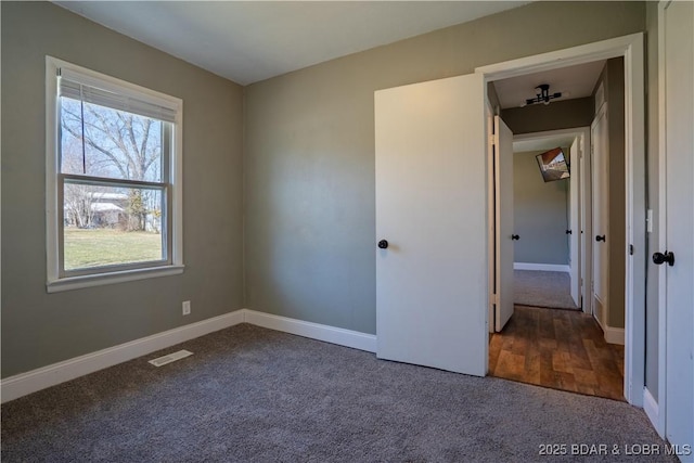 unfurnished bedroom featuring visible vents, baseboards, and carpet