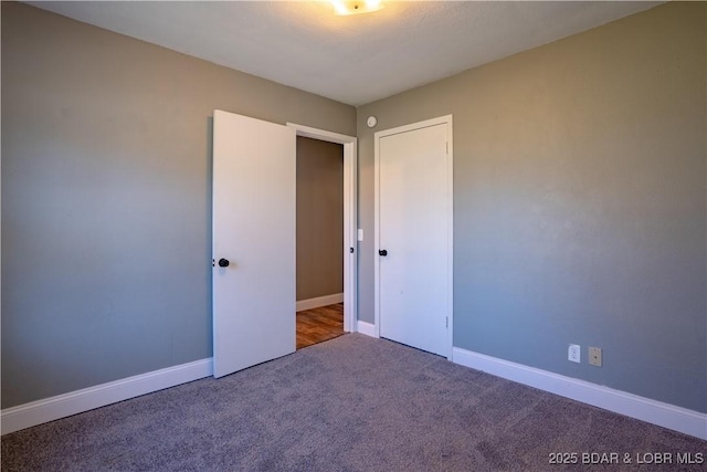 unfurnished bedroom with carpet and baseboards