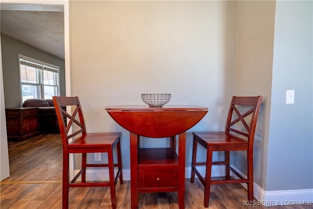 dining space with wood finished floors and baseboards