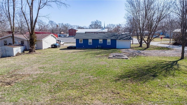 view of yard with an attached garage and driveway