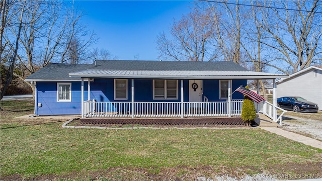 view of front of home featuring metal roof, a porch, and a front lawn