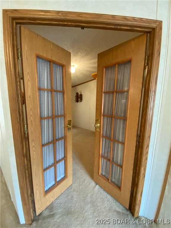 corridor with carpet floors and a textured ceiling