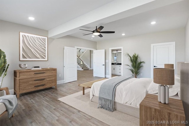 bedroom featuring wood finished floors, recessed lighting, baseboards, ceiling fan, and ensuite bathroom