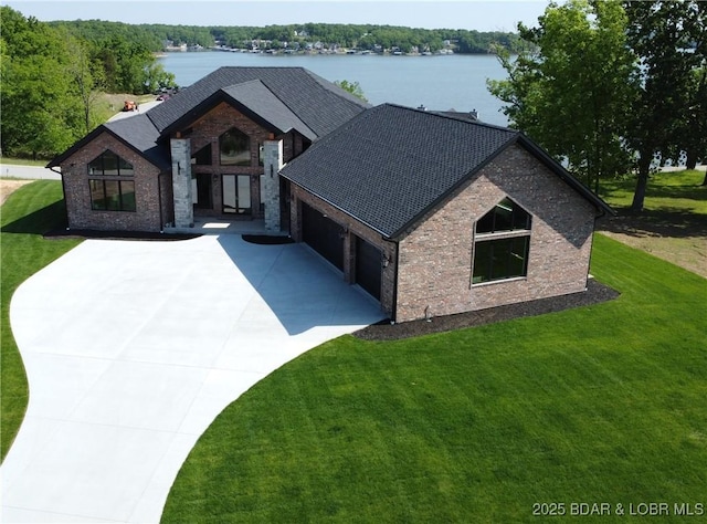 view of front of property with driveway, a garage, a front lawn, brick siding, and a shingled roof