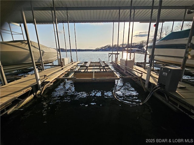 dock area featuring boat lift and a water view