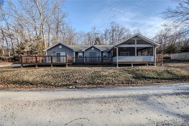 view of front of home with a wooden deck and a sunroom