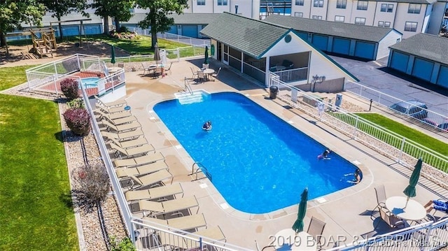 pool with fence, a lawn, and a patio area