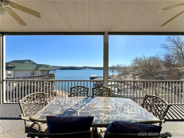 exterior space with a balcony, a water view, and a ceiling fan