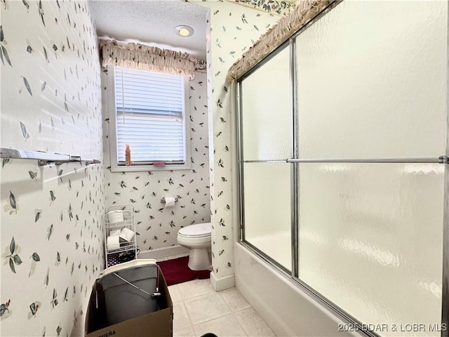 bathroom with wallpapered walls, toilet, tile patterned flooring, and a textured ceiling