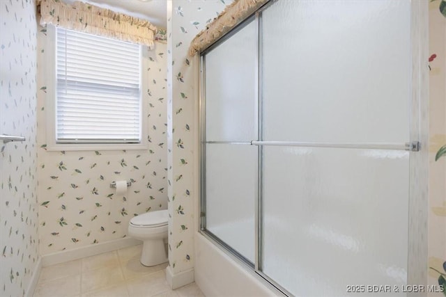 bathroom featuring tile patterned flooring, toilet, baseboards, wallpapered walls, and combined bath / shower with glass door