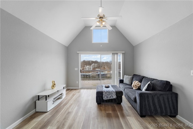 living room with ceiling fan, lofted ceiling, light wood-type flooring, and baseboards