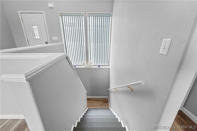stairway featuring wood finished floors and baseboards