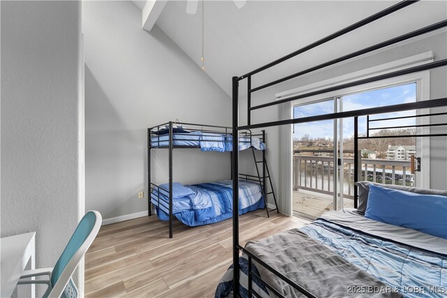 6504 Avalon Park, Osage Beach, MO 65065 - bedroom featuring wood finished floors, high vaulted ceiling, baseboards, a water view, and a textured wall