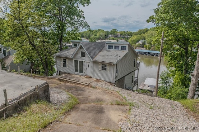 view of front of house with a water view and a shingled roof