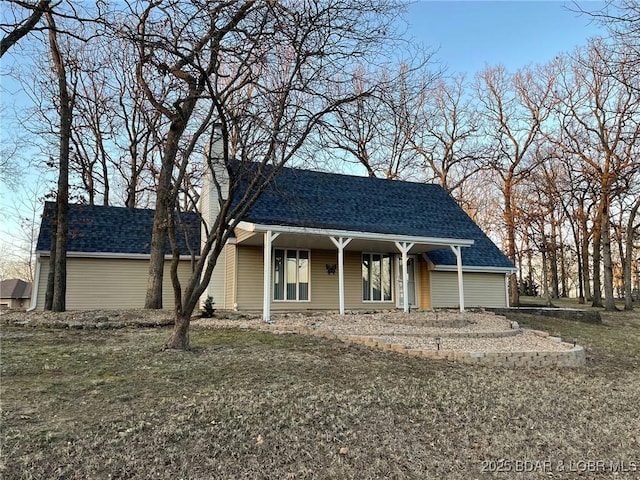 view of front facade with a front lawn and roof with shingles