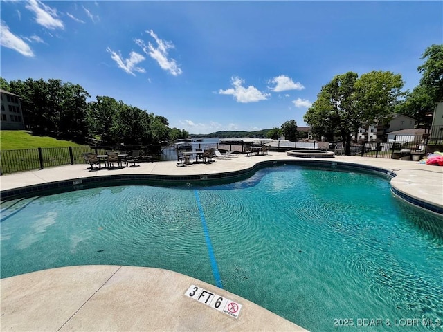 pool with a patio area and fence