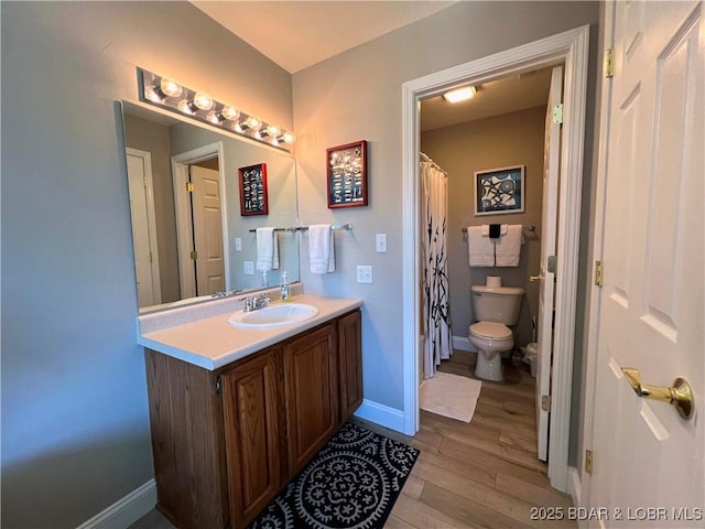 bathroom featuring curtained shower, baseboards, toilet, wood finished floors, and vanity