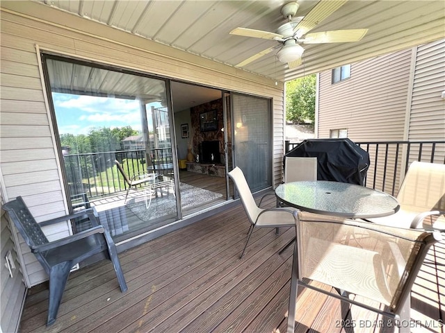 deck with a grill, outdoor dining area, and a ceiling fan