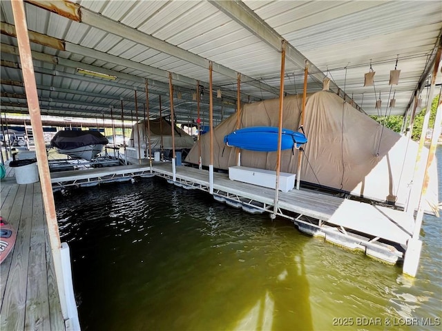 dock area featuring boat lift and a water view