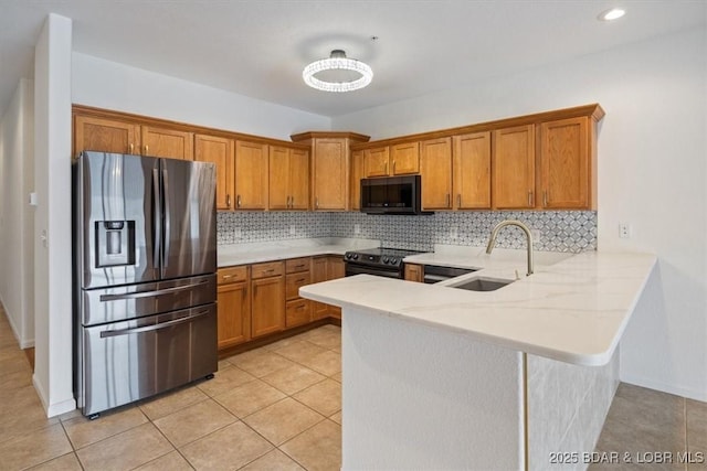 kitchen featuring brown cabinetry, black range with electric stovetop, stainless steel refrigerator with ice dispenser, and a sink