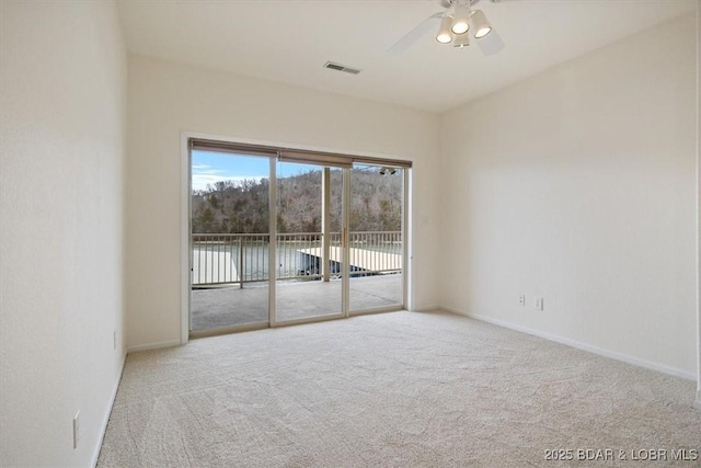 unfurnished room featuring ceiling fan, carpet, visible vents, and baseboards