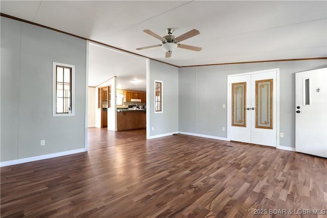 empty room featuring crown molding, ceiling fan, dark wood finished floors, lofted ceiling, and french doors