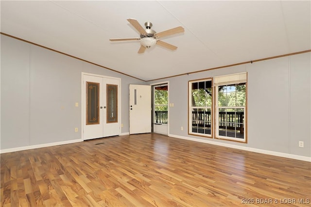 spare room with light wood-style flooring, baseboards, ceiling fan, and vaulted ceiling