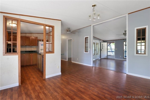 spare room with dark wood-type flooring, vaulted ceiling, and ceiling fan with notable chandelier