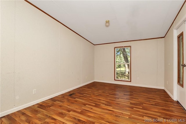 spare room with wood finished floors, baseboards, and ornamental molding